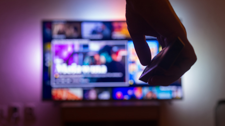 A person holding the remote of a smart TV.