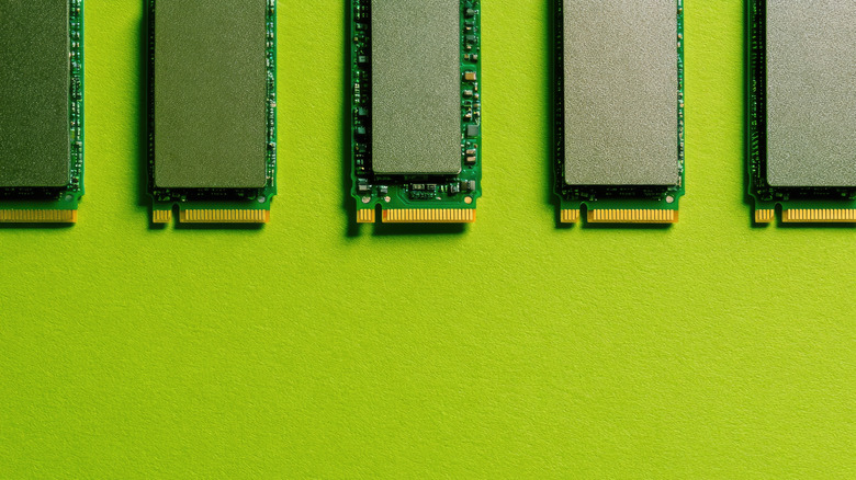 Several NVMe SSDs next to each other on a green surface.