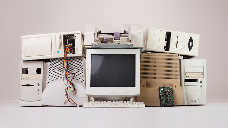 An assortment of old beige computer boxes with a CRT monitor in the middle.