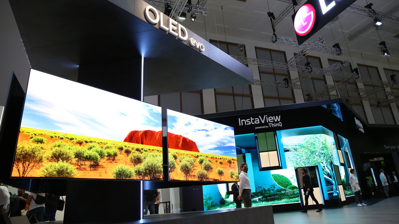 A showcase at an expo of two large LG EVO OLED TVs.