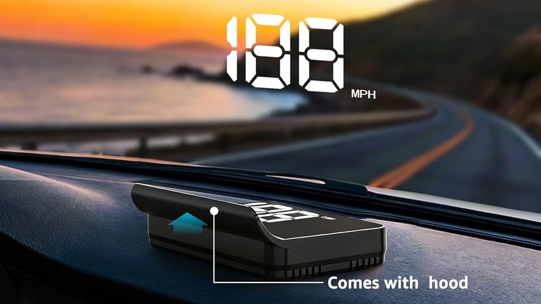 A black rectangular HUD gadget sitting atop a car's dashboard and emitting the car's current speed onto the windshield