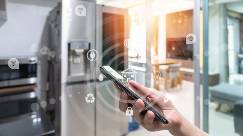 Smartphone in a kitchen with refrigerator and microwave in background