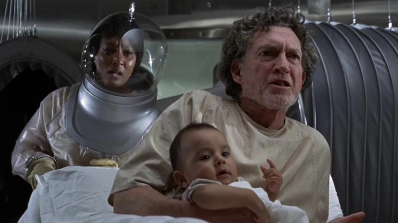 Jackson (George Mitchell) holding a baby in 