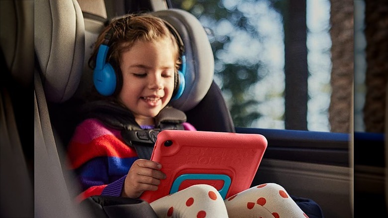 Girl using the Amazon tablet in a car.