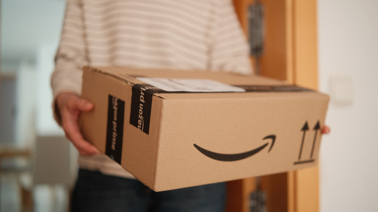 A person holding an Amazon box.