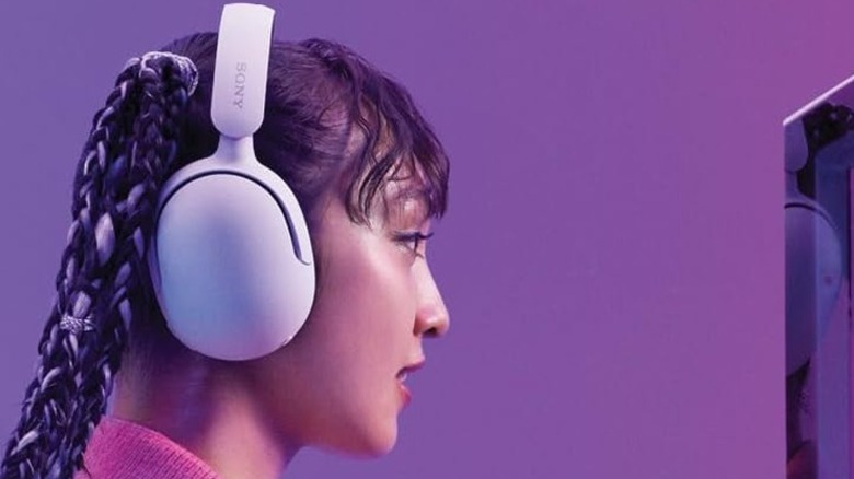 A person wearing the Sony Inzone H5 wireless gaming headset against a purple background