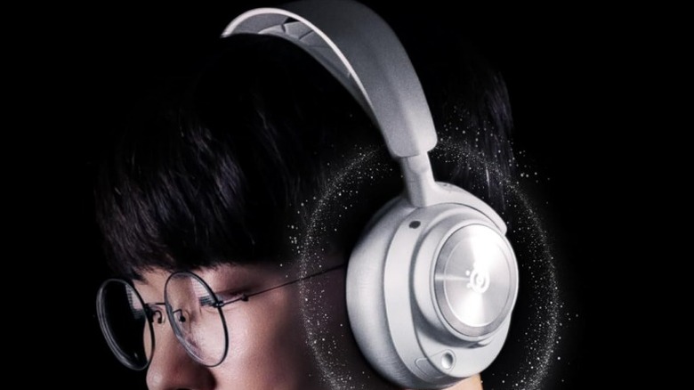 A person wearing a SteelSeries Arctis Nova Pro Wireless gaming headset against a black background