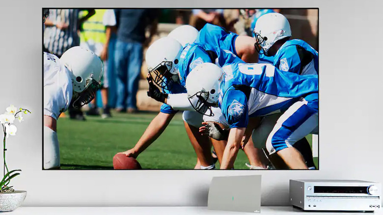 A TV showing a football game and a Mohu Gateway Plus antenna.