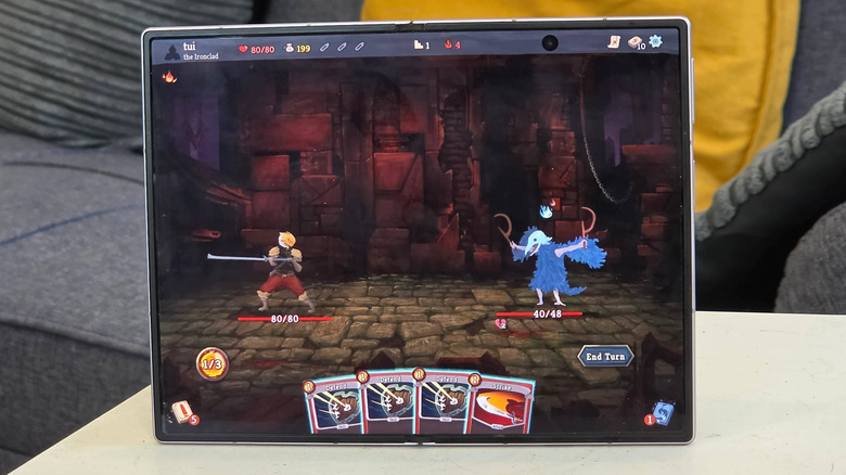 A Samsung Galaxy Z Fold 8 displaying the mobile video game "Slay the Spire."
