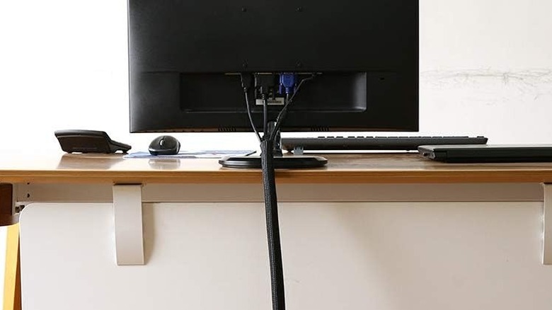 The Alex Tech Cable Sleeve wrapped around cables attached to a computer monitor.