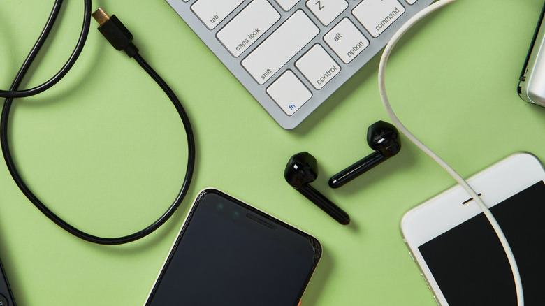A number of electrical appliances and phone accessories on a green surface