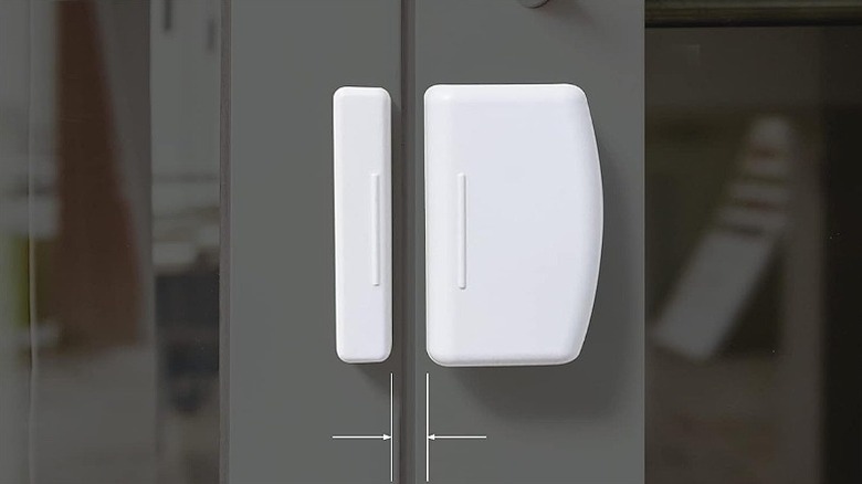 White contact sensor installed on a shiny surface.