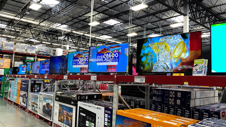 The TV aisle in a Sam's Club wholesale store, many TVs sitting on display on metal racks.