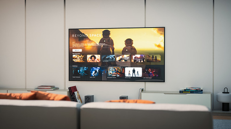 A TV mounted on a white wall displays a sci-fi show on a Smart TV interface.
