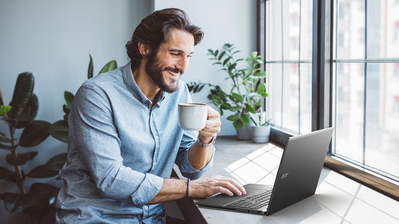 A person drinking coffee while working on the Acer Chromebook Plus 515