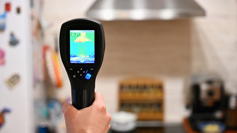 A person using a thermal camera in the kitchen.