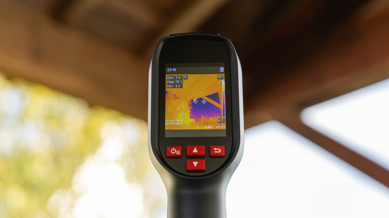 A thermal camera being used to detect heat loss on the roof.