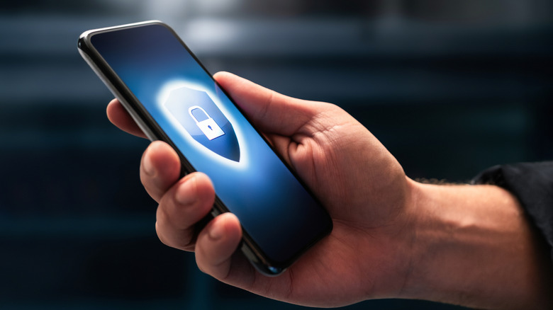 A hand holding a phone with lock sign on