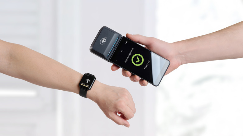 A person using their smartwatch for contactless payment.