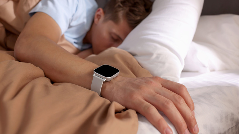 A person sleeping with a smartwatch on their wrist.