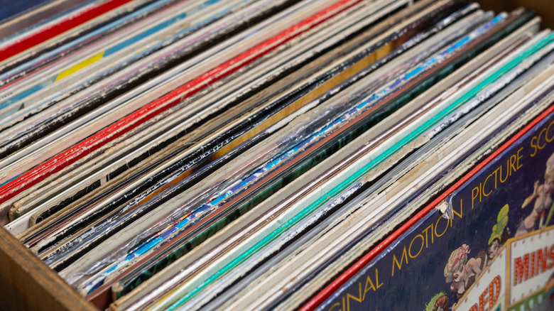 Crate filled with vinyl records stored vertically, showing the edges and album sleeves of a large record collection arranged for browsing.
