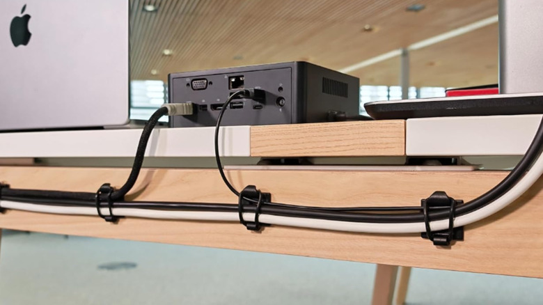 Computer cables are discreetly routed behind a desk using silicone ring cable clips
