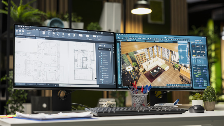 A pair of computer monitors showing interior design work on their screens.