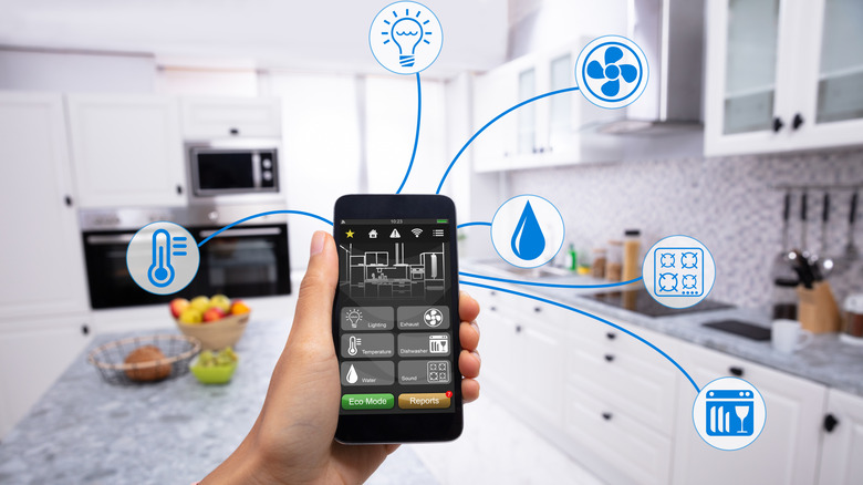 POV of a smartphone with different smart home control icons against a kitchen in the backdrop