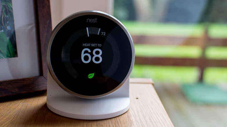 A Nest thermostat in a living room displaying the temperature