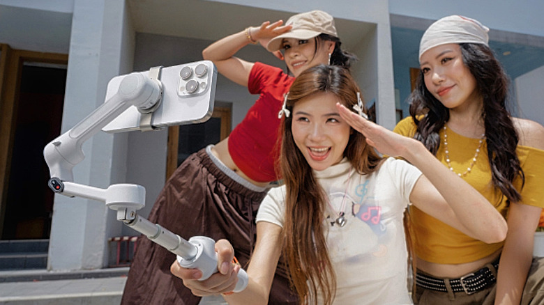 A group of women pose while using the Insta360 Flow 2 Pro on a smartphone.