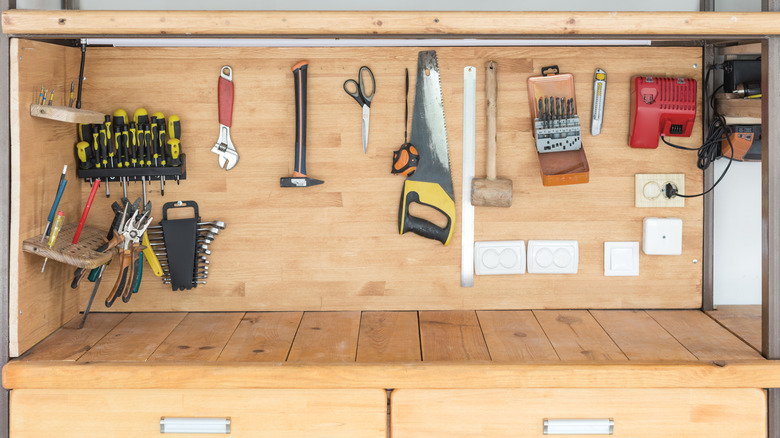 Different types of tools hanging on a workbench.