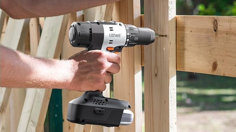 A person using the Litheli U20 Cordless Drill on a wooden fence.