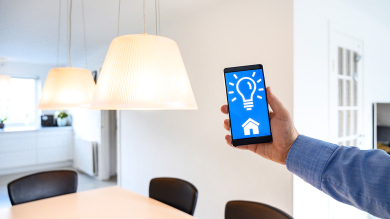 A person controlling multiple lights with a phone