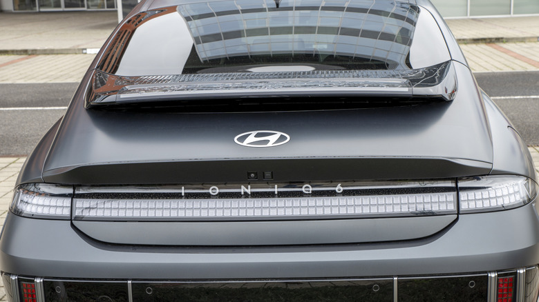 A gray Ioniq 6 as seen from the rear, with the Hyndai badge and Ioniq 6 logo showing.