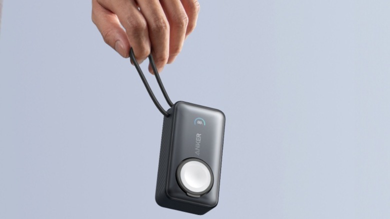 A person holding the Anker MagGo power bank for Apple Watch.