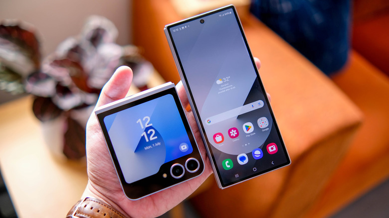 Two folding phones, one unfolded, sit on a person's hand.