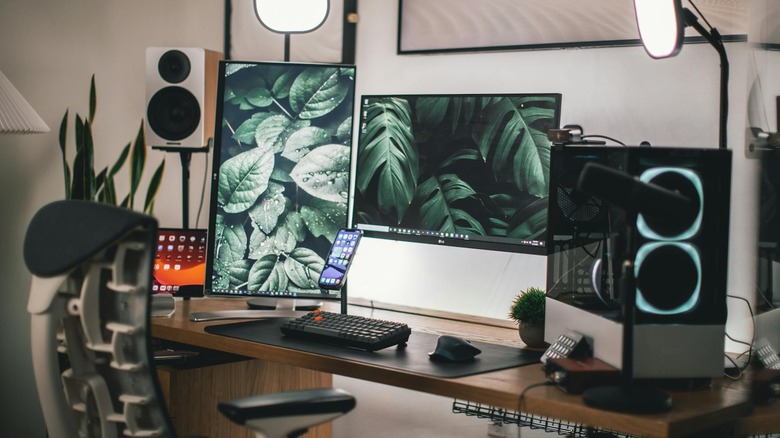 Two monitors on a desk at variable heights, one of which is vertical