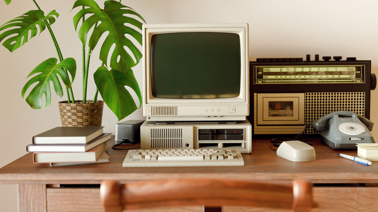Retro-inspired office space with old desktop computer and audio equipment