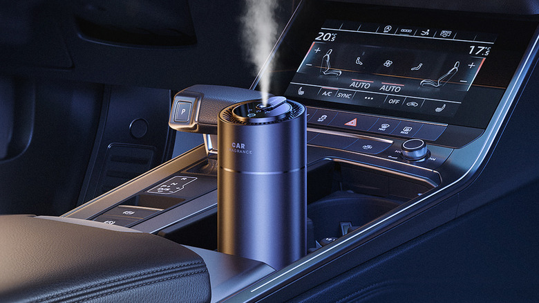 The Ceeniu F26 car air freshener in the drink holder of a car.