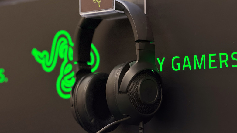 Razer headphones hanging on the side of a Razer board