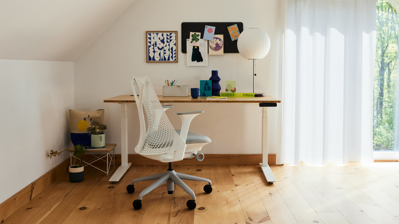 The Herman Miller Jarvis Bamboo standing desk with various items on its surface.