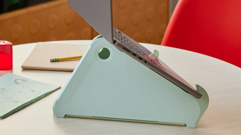 The Herman Miller Oripura laptop stand on a table, holding a laptop.