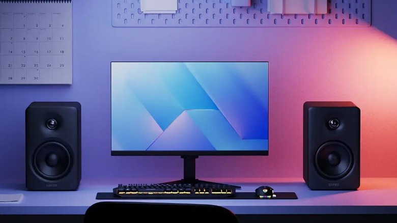 A desk setup showing the Edifier M90 computer speakers surrounding a monitor, a keyboard, and a mouse.