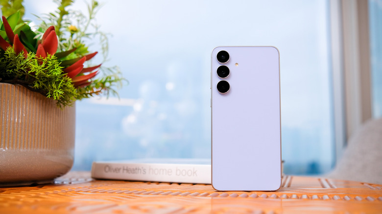 The back of a Samsung Galaxy S25 FE smartphone, standing on a table