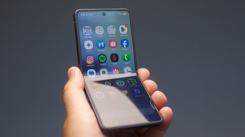 A hand holding a Galaxy Z Flip 7 smartphone