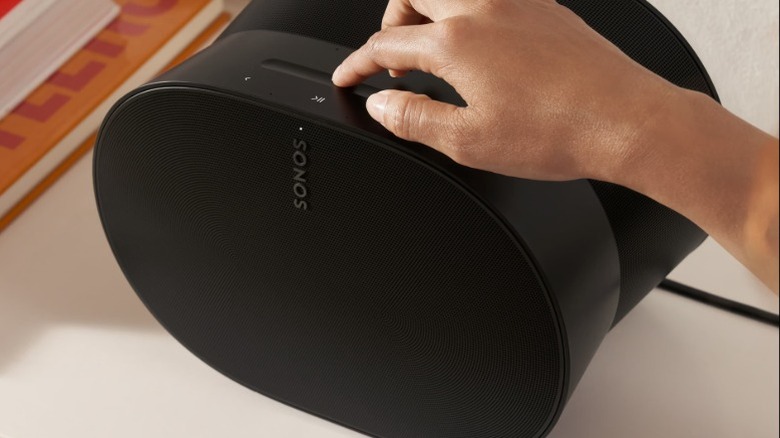 A person interacting with the Sonos Era 300 SL wireless speaker.