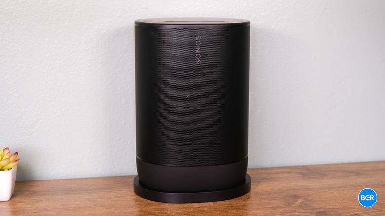The Sonos Move 2 speaker sitting on a table, with a a small plant visible in the left corner.