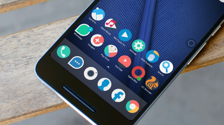 A smartphone using the Minimal O icon pack, lying on a wooden bench