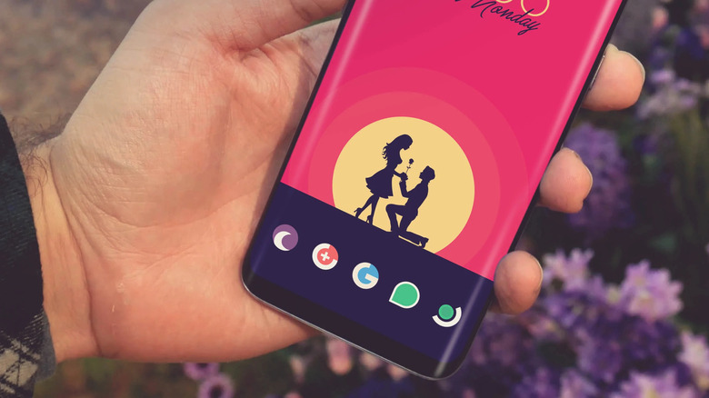 Holding the phone with the Minimalist icon pack and a romantic wallpaper
