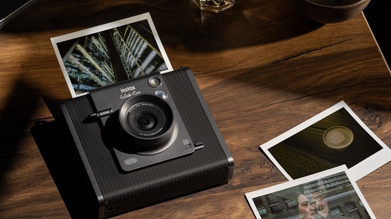Fujifilm Instax Wide Evo lying on a wooden table printing a photo